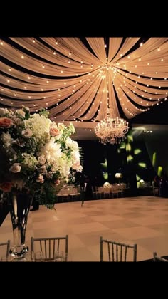 an elegant wedding setup with chandeliers and flowers in vases on the dance floor