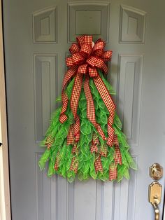 a door with a green wreath and red bow hanging on it's front door