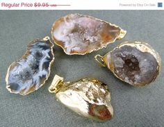 three pieces of gold and one piece of agate on a gray surface with other items in the background