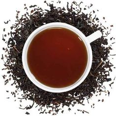 a cup of tea is surrounded by black leaves