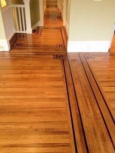 an empty hallway with wooden floors and white trimmings on the walls, along with hardwood flooring