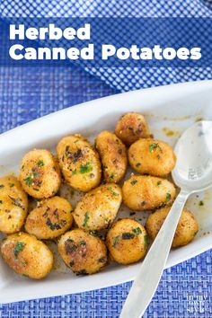 a white bowl filled with fried potatoes on top of a blue table cloth next to a spoon