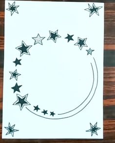 a paper with stars on it sitting on top of a wooden table next to a pen