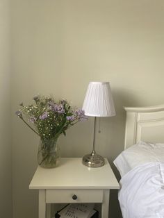 A vase of purple and white flowers on bedside table with a lamp White And Lavender Bedroom Aesthetic, Flower Bedside Table, Lilac Bedroom Ideas Aesthetic, Purple Flower Room Decor, Aesthetic Lavender Room, Bed Lamp Aesthetic, Purple And White Room Aesthetic, Lavender Room Ideas Aesthetic, Aesthetic Bedside Lamp