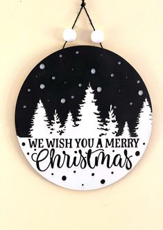 a black and white christmas sign hanging on the side of a wall