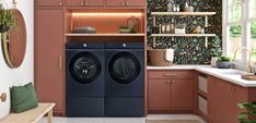 a washer and dryer in a room with wooden cabinets on either side of the door