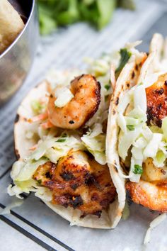 two shrimp tacos with coleslaw and slaw