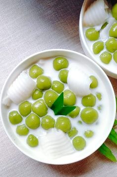 two bowls filled with green olives and cream