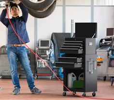 a man working on a tire in a garage with an air hose attached to it