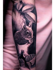 a woman's arm with a squirrel and leaves on it