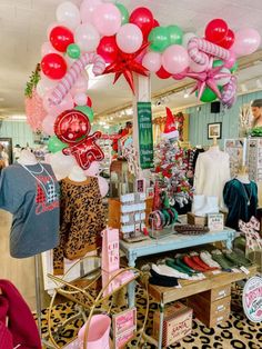 a store filled with lots of pink and green balloons