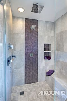 a walk in shower sitting next to a glass door and tiled wall with shelves on each side