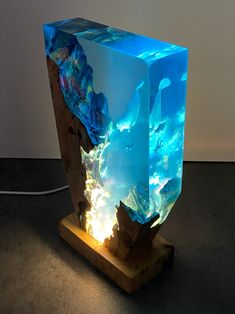 an illuminated cube sculpture on a wooden stand