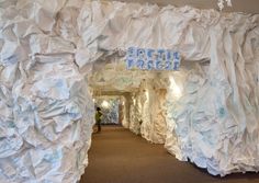 an archway made out of white paper with blue writing on it