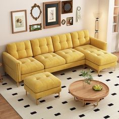 a living room with yellow couches and pictures on the wall above it, along with a coffee table