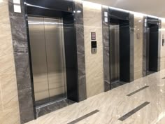 an elevator with three elevators in it and no doors on either side, next to another one