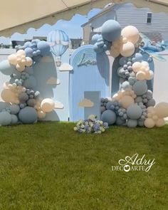 balloon arch in front of a blue and white building with balloons on it's sides