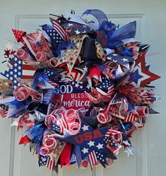 a patriotic wreath with red, white and blue ribbons on the front door for memorial day