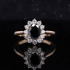 an oval black diamond surrounded by small white diamonds on a gold band, set against a black background