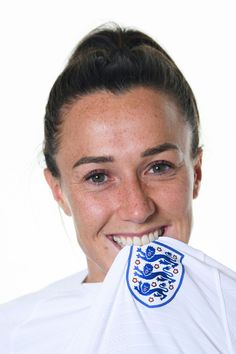 a woman with a white shirt holding a blue and white object in her mouth