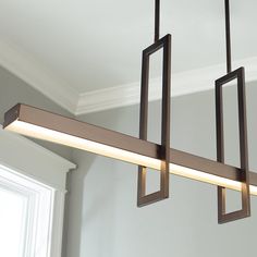 a rectangular light fixture hanging from the ceiling in a room with white walls and windows