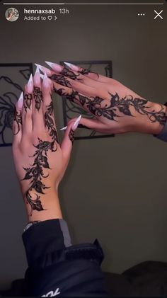 two hands with henna tattoos on their palms and one holding the other's hand