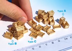 a person is holding some type of wooden blocks and measuring it with a ruler in front of them