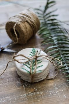 some twine is tied up and sitting on a wooden table next to a spool of string