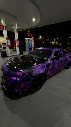 a purple camouflage camo car parked at a gas station