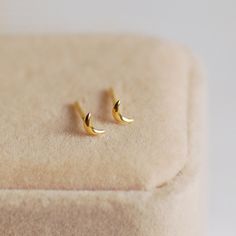 Shoot for the moon with these stunning Tiny Gold Crescent Moon Stud Earrings. The perfect present for someone special, or as a treat to yourself, these pretty earrings are very dainty. Made from gold-plated sterling silver, they can be worn every day and would look great as a second piercing. Your earrings will arrive beautifully gift wrapped in white tissue, in a Carriage Trade gift box, free of charge. Studs measure 5mm in length and come with butterfly backs. If you have any questions, please let me know. Minimalist Crescent Earrings For Gift, Minimalist Crescent Earrings As Gift, Minimalist Half Moon Earrings For Gift, Dainty Half Moon Earrings With Moon Charm, Dainty Half Moon Charm Earrings, Dainty Single Moon Earring, Minimalist Round Earrings With Moon Charm, Minimalist Moon Shaped Single Earring, Minimalist Moon-shaped Cartilage Earrings