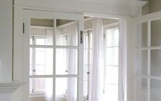 an empty room with white walls and glass doors