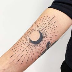 a person with a tattoo on their arm that has the sun and moon in it