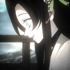 a woman with long black hair standing in front of a window looking at the sky