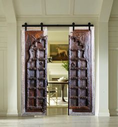 an open wooden door in the middle of a room with white walls and flooring