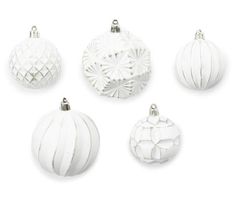 six white ornaments are arranged on a white surface, including one with an ornament in the center