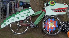 a bike decorated like a crocodile is parked next to a tree