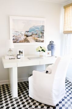 a white desk and chair in a room with black and white checkered flooring