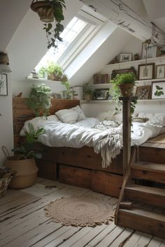 a bed sitting under a window next to a stair case in a room filled with plants