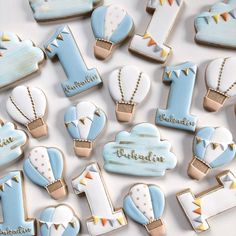 baby shower cookies are arranged on a white tablecloth with gold trimmings and blue icing