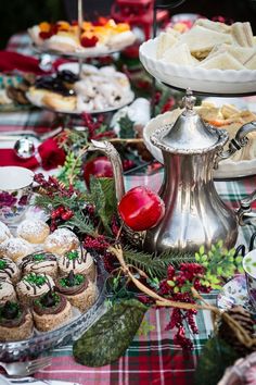 a table topped with lots of desserts and pastries next to a silver tea pot