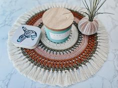 a cup of tea and an air plant on a doily next to some yarn