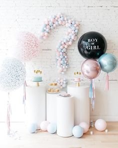 balloons and confetti are on display in front of a white brick wall with the word boy girl