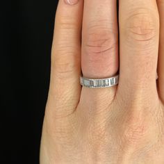 a woman's hand with a wedding ring on her left hand, showing the band