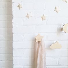 there is a white brick wall with stars and clouds on it, next to a pink blanket