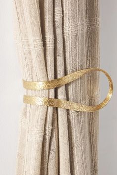 a curtain with gold metal straps hanging from it's side