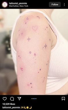 the back of a woman's arm with small stars on it and hearts in the sky