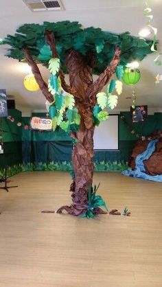 an indoor area decorated with fake trees and paper mache decorations on the walls, along with other items