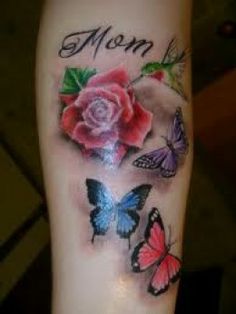 a rose and three butterflies on the arm with one pink rose in the middle, another blue butterfly at the bottom