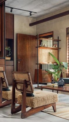 a living room filled with furniture and lots of wood accents on the walls, along with wooden shutters