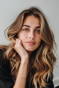 Portrait of a woman with wavy blonde hair and green eyes, resting her chin on her hand, gazing at the camera. Bronde Balayage Hair, Warm Bronde, Deep Messages, Blondes Have More Fun, Bottle Blonde, Balayage Blond, Blonde Hair Transformations, Bronde Balayage, Bronde Hair